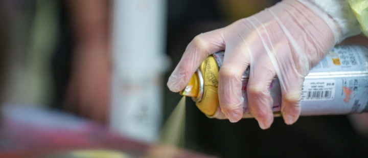 Hand mit Sprühdose sprüht Graffiti