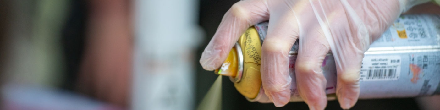 Hand mit Sprühdose sprüht Graffiti